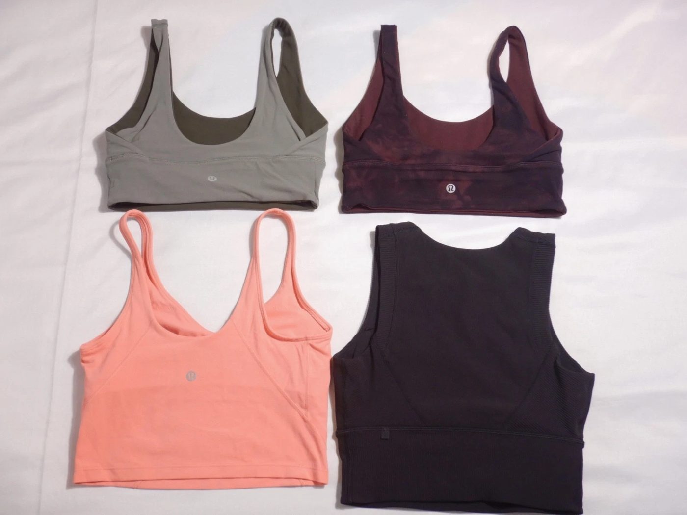 Flat-lay of pre-owned lululemon tops & tanks from a ThriftUp wholesale lot